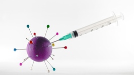 Abbildung einer Spritze mit einem Modell eines Coronavirus