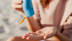 Frau trägt Sonnencreme auf