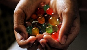 Hände halten bunte Wasserperlen