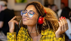 Frau hört mittels Kopfhörer Musik