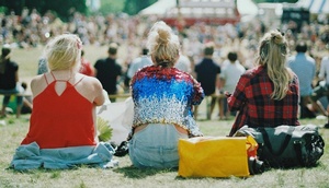 Open-Air-Konzert, im Vordergrund 3 Frauen, die mit dem Rücken zur Kamera sitzen