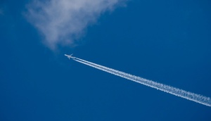 Flugzeug mit Kondensstreifen am Himmel