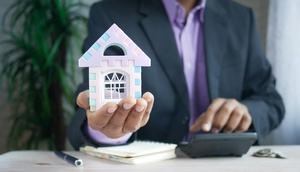 Mann hält Modellhaus in der Hand