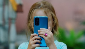 Mädchen hält Smartphone vor Gesicht