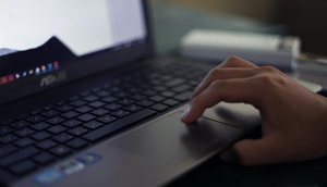 Hand scrollt auf Mousepad von Notebook