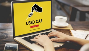 Laptop mit gelben Bildschirm und Schriftzug "used car"