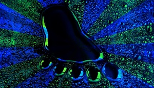 Fußabdruck aus glitzernder Flüssigkeit auf blau-grünem Strahlen Hintergrund  