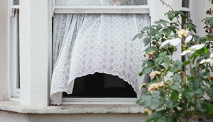 offenes Fenster, Vorhang weht im Windzug 