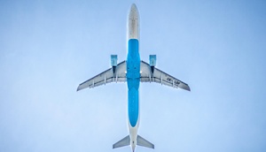Fliegendes Flugzeug von unten vor blauem Himmel
