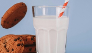 Glas Milch neben Cookies