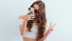 Mädchen das mit einem Victory-Zeichen ein Selfie macht 