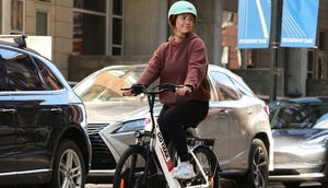 Frau mit Helm auf einem E-Bike