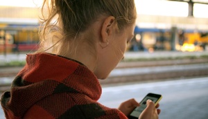 Teenagerin schaut auf Smartphone