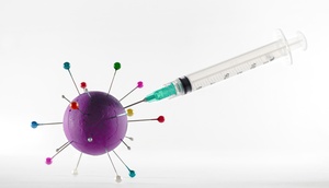 Abbildung einer Spritze mit einem Modell eines Coronavirus