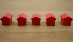 kleine, in einer Reihe stehenden, rote Holzspielzeughäuschen