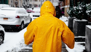 Mann geht durch verschneite Straßen