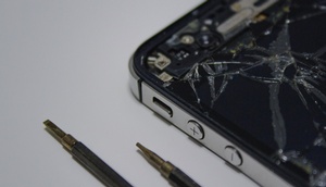 kaputtes Smartphone, daneben Schraubenzieher  