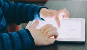 Kinderhände tippen auf Tablet
