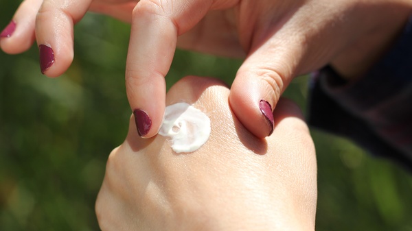 2 Frauenhände, weiße Creme am Handrücken, © Ana Essentiels auf Unsplash