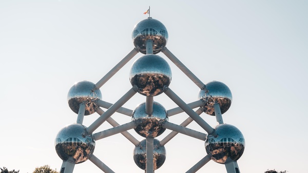 Atomium, Wahrzeichen in Brüssel, ein auf einer Ecke stehendes Modell der aus neun Atomen bestehenden Elementarzelle der Kristalle, © Maurice Sahl auf unsplash
