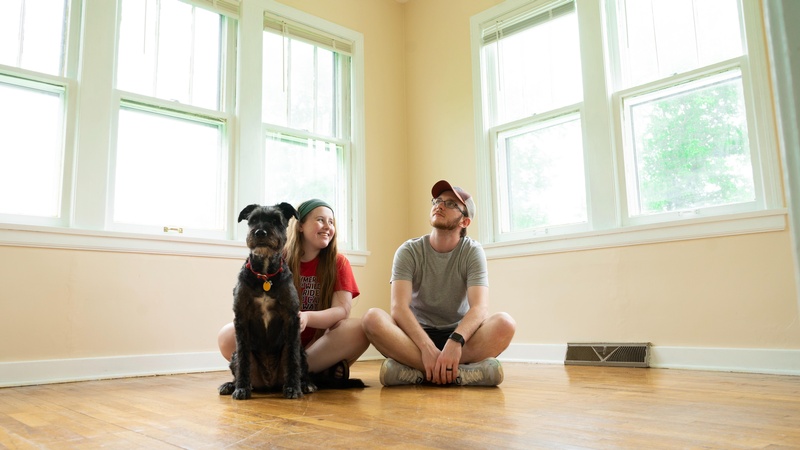Junge Frau, junger Mann, Hund sitzen am Boden einer hellen, leeren Wohnung, © Andrew mead on unsplash