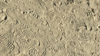 Fuß- und Schuhabdrücke im Sand