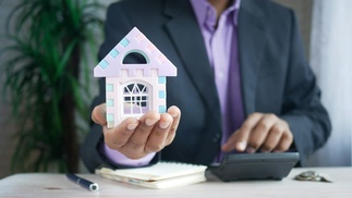 Mann hält Modellhaus in der Hand