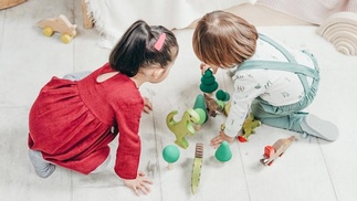 zwei Kinder spielen mit Spielfiguren