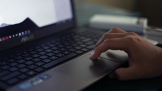 Hand scrollt auf Mousepad von Notebook