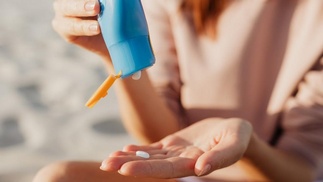 Frau trägt Sonnencreme auf
