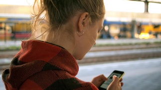Teenagerin schaut auf Smartphone