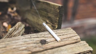 Zigarette brennt auf Holz ab