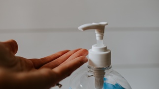 Handfläche mit Desinfektionsmittelflasche 