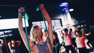 Gruppe mit Therabändern im Fitnesscenter