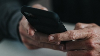 Männerhände halten ein Handy