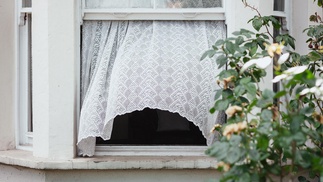 offenes Fenster, Vorhang weht im Windzug 