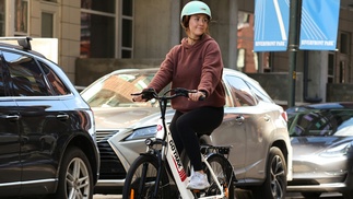 Frau mit Helm auf einem E-Bike