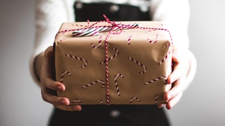 Frauenhände halten ein Weihnachtsgeschenk