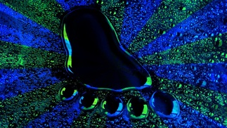 Fußabdruck aus glitzernder Flüssigkeit auf blau-grünem Strahlen Hintergrund  