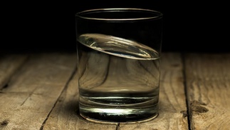 Glas mit Wasser auf Holztisch